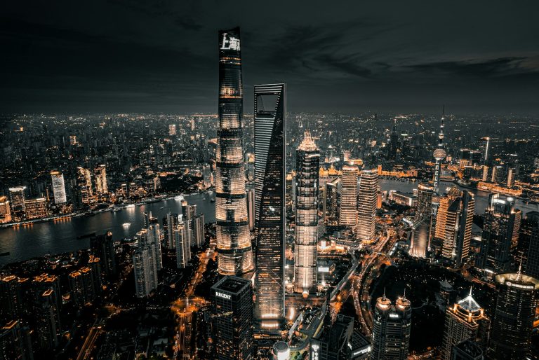Vue aérienne de Shanghai illuminée la nuit, avec les gratte-ciel de Lujiazui et la rivière Huangpu